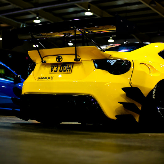 A yellow sports car parked next to a blue sports car