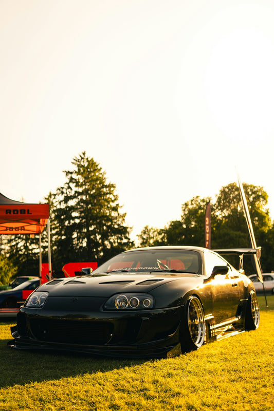 Modified black sports car parked on grass