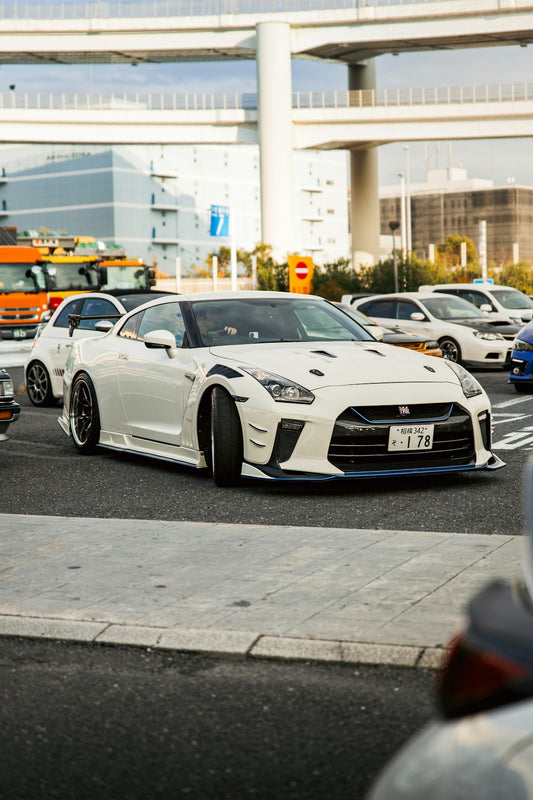 White nissan gt-r driving on a city street.