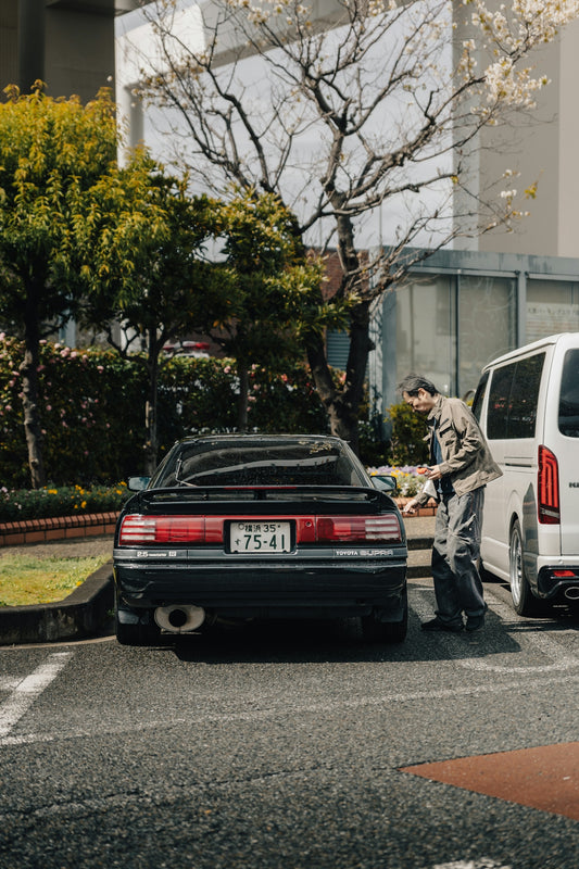 Man leaning on a black vintage car
